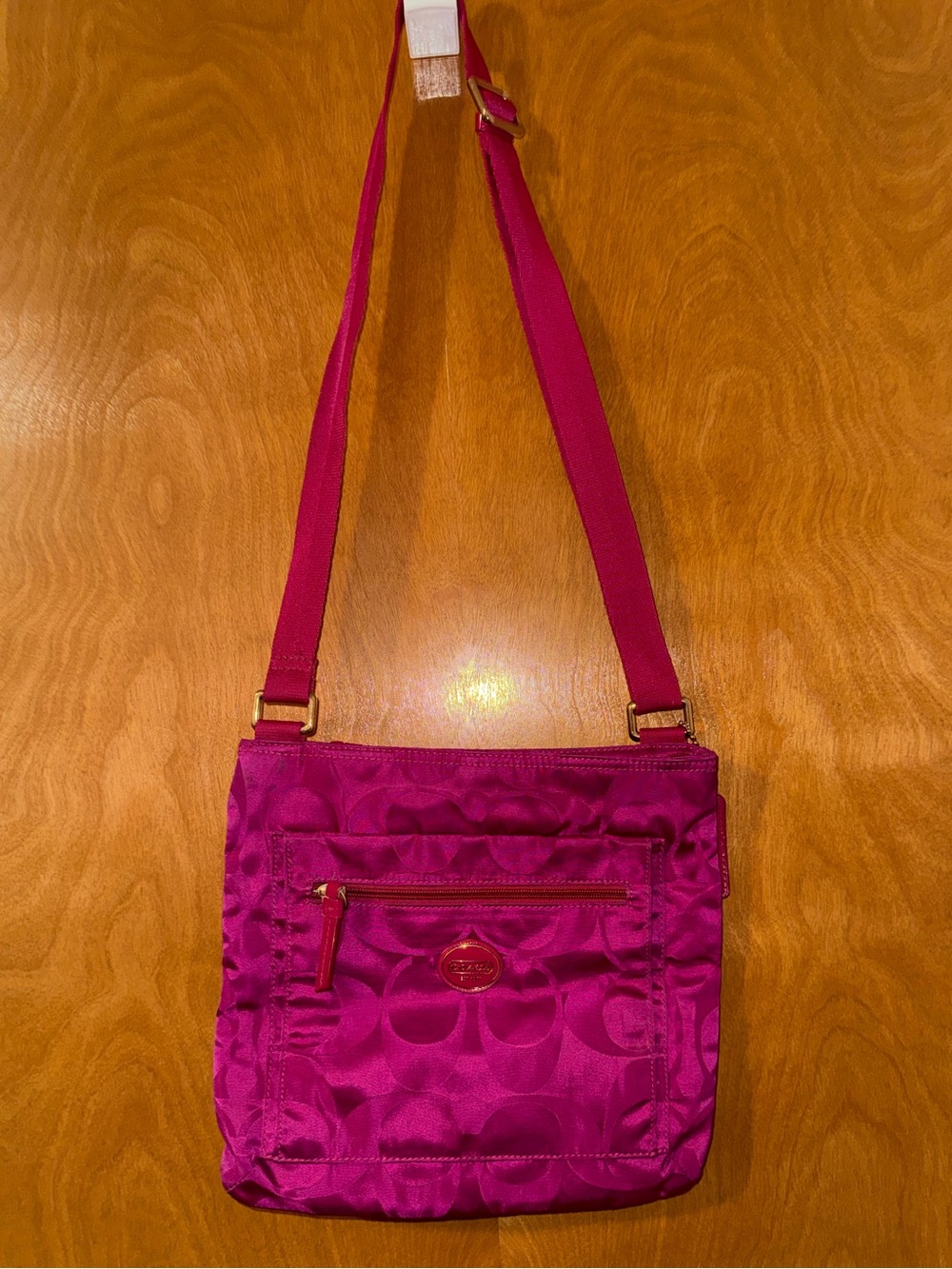 Coach hot pink crossbody bag with a long, adjustable strap